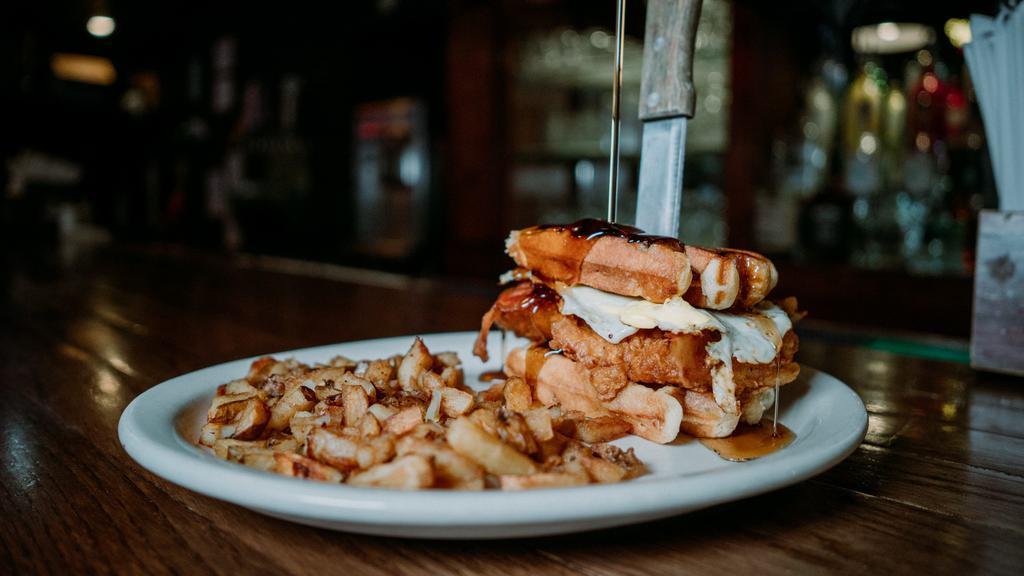 Chicken N' Waffles · edwin style chicken breast, fried egg, & bacon stuffed  between 2 pearl sugar belgian waffles, served w/ a side of syrup & homemade potatoes