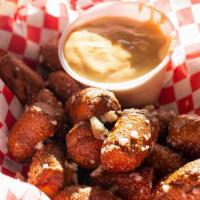 Pretzel Bites · Lightly fried pretzel bites tossed with truffle oil, parmesan cheese and served with queso.