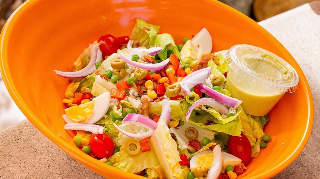 Chopped Salad · Chopped baby romaine hearts, tomatoes, red onions, bacon, roasted corn, peas, red peppers, sliced green olives, hard boiled egg, bleu cheese crumbles, citrus vinaigrette