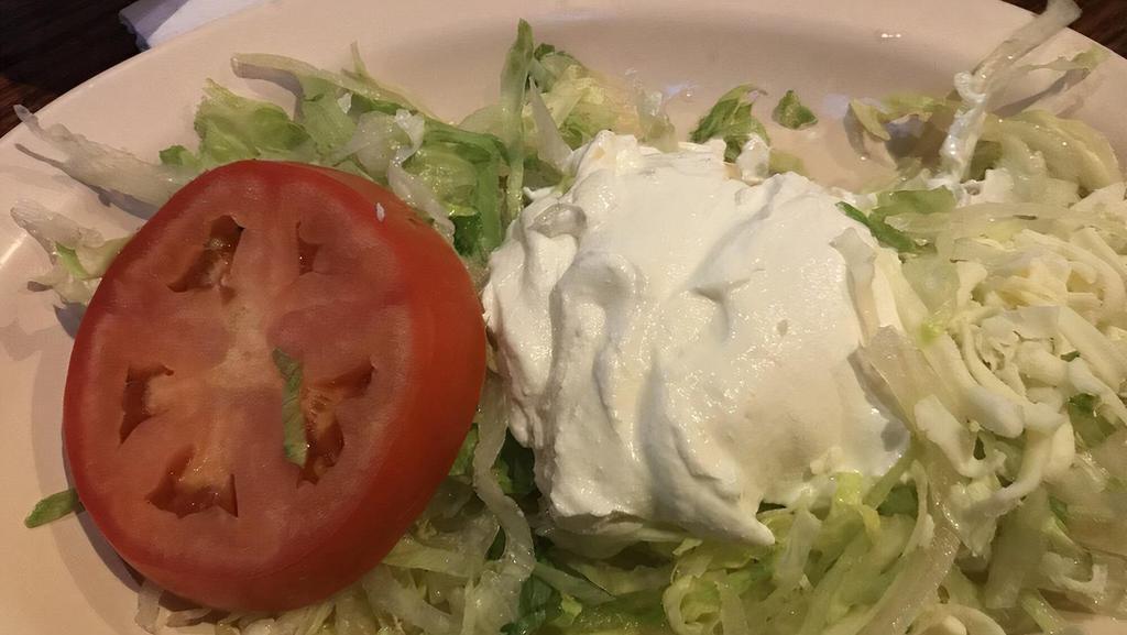 Taco Salad · Our choice of seasoned ground beef or shredded chicken. Prepared with onion, tomatoes, and bell peppers. Topped with lettuce cheese sauce, shredded cheese, pico de gallo, sour cream, and guacamole in a crispy tortilla shell.