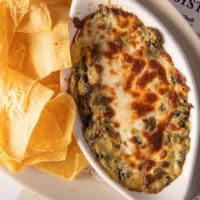 Spinach & Artichoke Dip · A creamy blend of spinach and artichoke topped with mozzarella cheese, served with tortilla ...