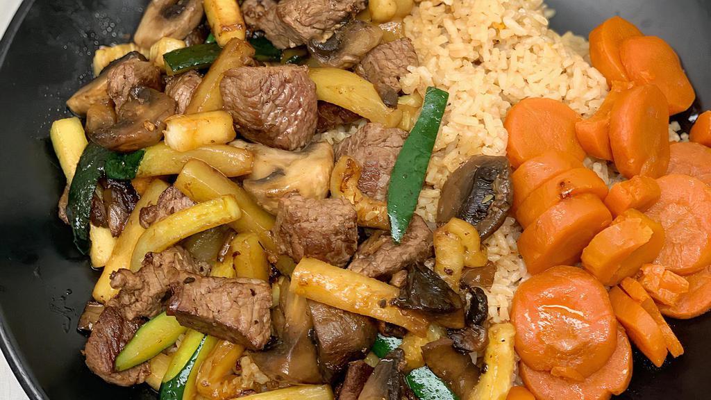 Rib Eye Steak Hibachi · USDA choice lean rib eye steak, grilled to a juicy and medium well. Grilled with zucchini and mushrooms in a ginger soy sauce. Served over Japanese fried rice and sweet carrots. It is pre cooked so please note it can only be cooked medium - well done.