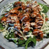 The Buffalo Chicken Salad · Fresh Spinach topped with breaded chicken cooked in our house made buffalo sauce, diced toma...