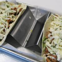 Hot Chicken Tacos · Start with fresh avocado and topped with smoked pulled chicken cooked in our house made Nash...