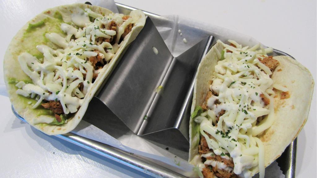 Hot Chicken Tacos · Start with fresh avocado and topped with smoked pulled chicken cooked in our house made Nashville hot rub. Topped off with mozzarella cheese and a ranch drizzle.