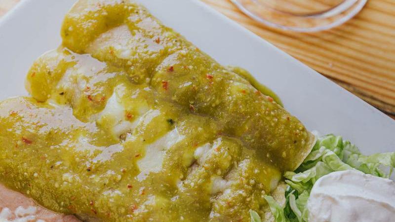 Enchiladas Suizas · 3 steak or grilled chicken enchiladas topped with green tomatillo sauce. Served with lettuce, sour cream, pico de gallo, beans, and rice.
