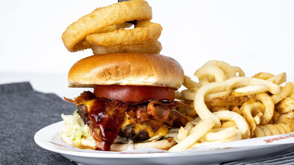 Western Bbq Burger · Bbq sauce, melted cheddar cheese, bacon and onion rings piled high on a toasted brioche bun. giddy up. served with choice of side.