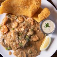 Deleon Catfish · Two fillets of crispy fried catfish served on our shrimp etouffee and rice. Comes with a sid...