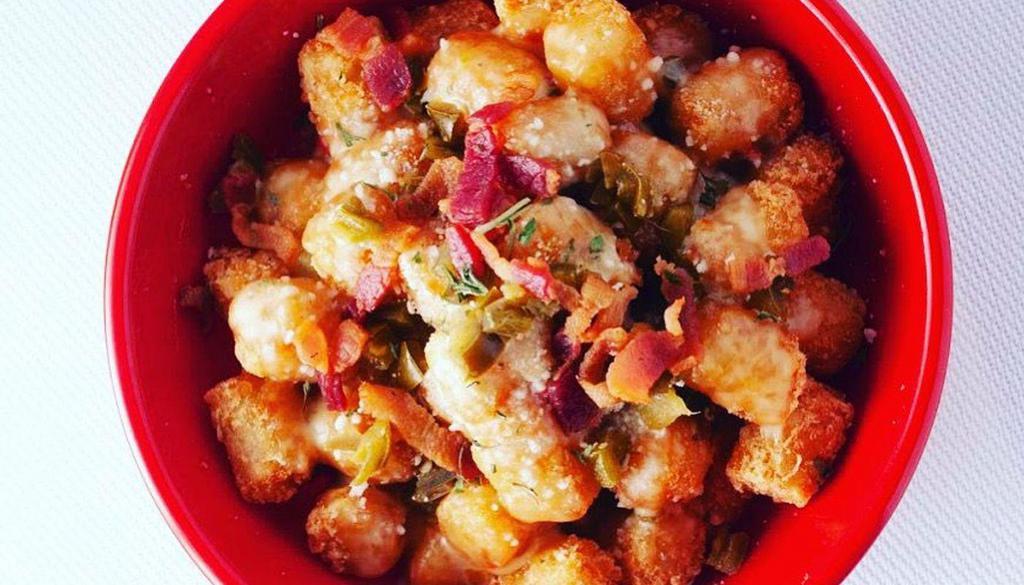 Super Tots · Crispy tots topped with queso, bacon, jalapeno and jack cheese.
