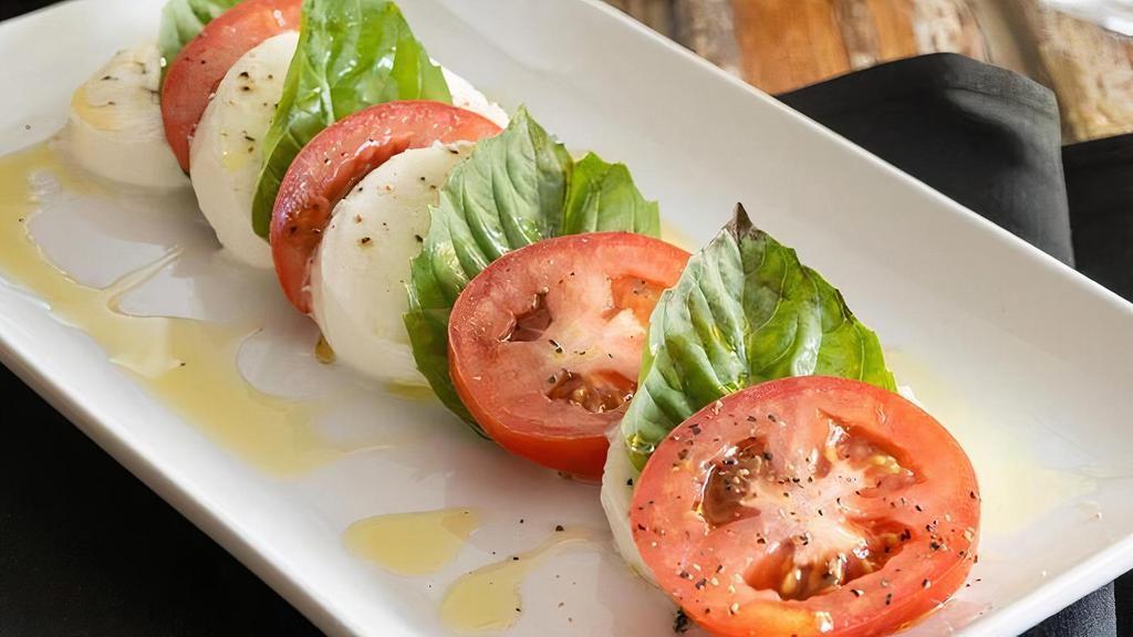 Caprese Salad · Fresh Mozzarella, sliced tomatoes, basil, Kalamata Olives, Balsamic glaze drizzle and olive oil.