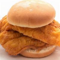 Kids Catfish Sandwich · A kids sized portion of catfish on a small bun, one side and a small drink.