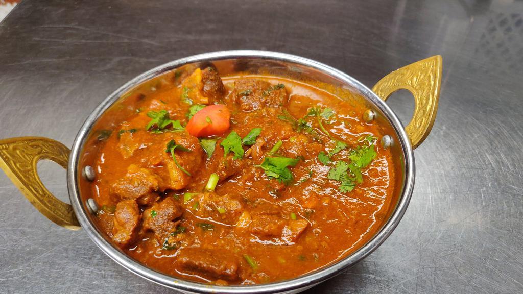 Goat Curry · Gluten free. Goat meat with bone, traditional dish of Nepal, carefully seasoned with the exotic blend of curry spices, onion, garlic, ginger and tomatoes in a medium-thick sauce.