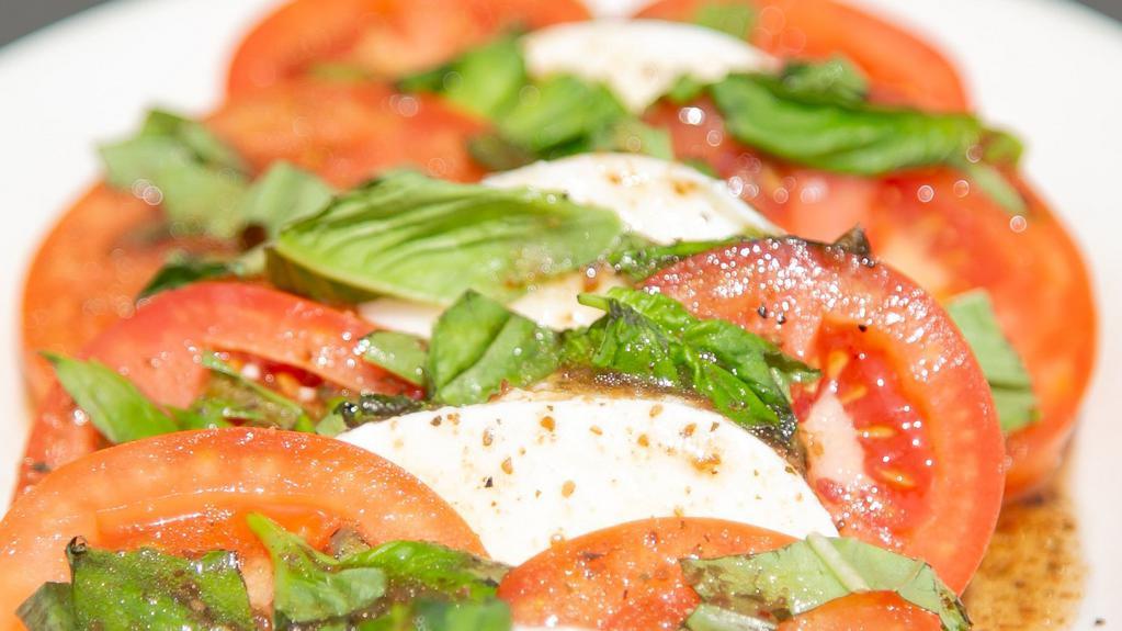 Mozzarella & Tomato Salad · Fresh mozzarella and roma tomatoes, served with balsamic Italian vinaigrette dressing and garnished with fresh basil.
