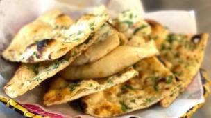 Garlic Naan · Tandoor-baked white flour bread with garlic and butter.