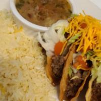 Crispy Tacos · Three crispy tacos with ground beef, lettuce, tomatoes, and yellow cheese, rice, and charros...