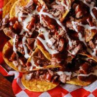 Bar-B-Q Nachos · Smoked, chopped pork shoulder on a bed of tortilla chips topped with white queso, original m...