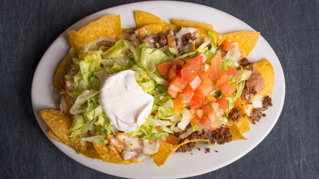 Nachos Deluxe · Cheese Nachos With Beans, Shredded Chicken And Ground Beef. Topped With Lettuce, Tomato, And Sour Cream.