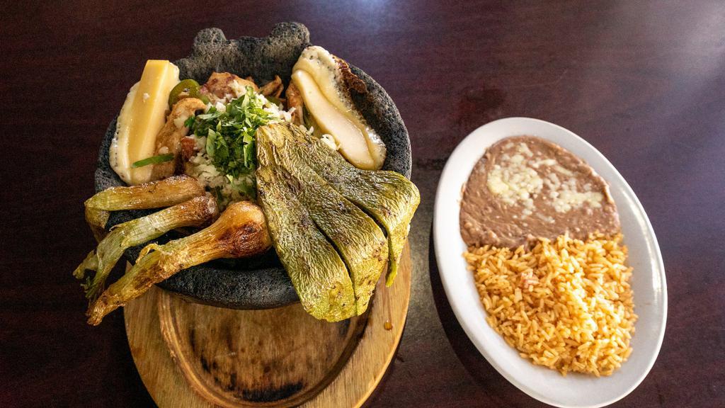 Molcajete · Steak, grilled chicken, or mixed  in a ranchera sauce sauteed with bell pepper onions, and tomatoes, knob onions and grilled cactus. Garnish with cilantro and shredded cheese. served with rice, beans and tortillas.