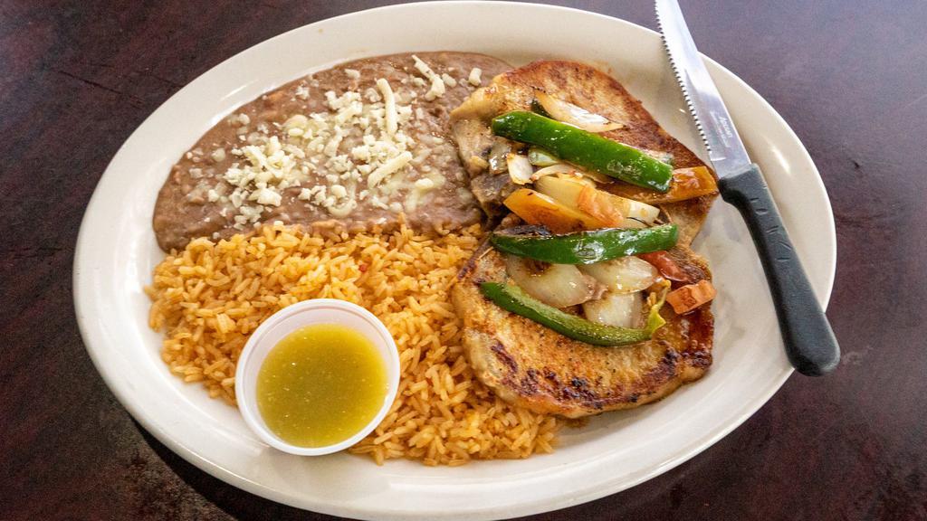 Chuletas Mexicanas · Two seasoned pork chops topped with onions, jalapenos, tomatoes and your choice of ranchero or tapatio sauce. Served with rice, beans and tortillas.