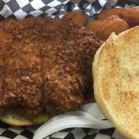 Iowa Tenderloin Sandwich · A thick slice of pork loin pounded out flat and seasoned then breaded and deep fried and ser...