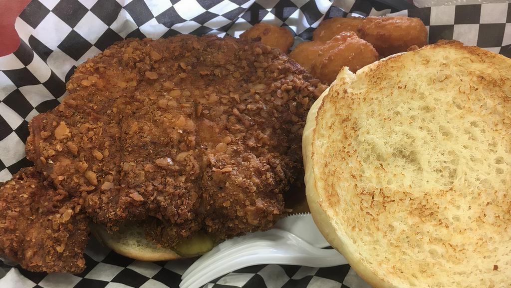 Iowa Tenderloin Sandwich · A thick slice of pork loin pounded out flat and seasoned then breaded and deep fried and served on a bun with pickles.