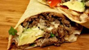 Azada Burrito · A flour tortilla filled with steak or grilled chicken covered with cheese sauce, served with...