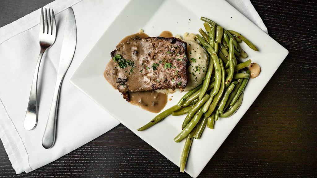 The Meatloaf · It is homemade meatloaf with a slight spicy twist, served over garlic mashers all smothered in our beefy mushroom gravy with a side baby green beans