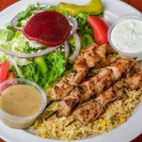 Chicken Souvlaki · Two chicken skewer. Served over rice, pita bread, and a side.