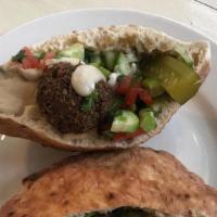 Falafel Pita · Falafel served in a pita and dressed with hummus, tahini, Israeli salad, and pickles.