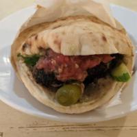Beef Kebab Pita · Grilled beef kebab served in a pita, and dressed with tahini, parsley, salad, and pickles. S...