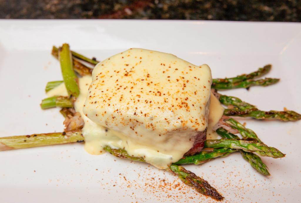 Steak Oscar · Grilled steak filet, topped with jumbo lump crab meat and bearnaise sauce, served with asparagus.
