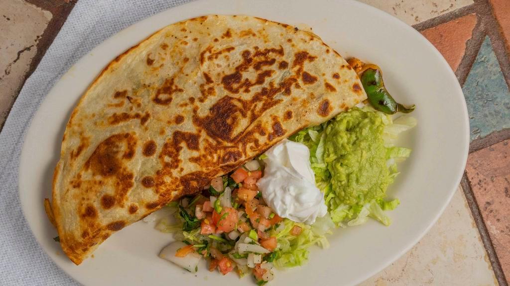 Fajita Quesadilla · A flour tortilla grilled and stuffed with grilled ribeye or chicken and topped with shredded cheese, onions, and bell peppers. Served with guacamole salad and sour cream.