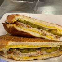 Cubano Sandwich · Local Slow Cooked Roast Pork in Moho Sauce, Cooked Ham slices, Swiss Cheese, Pickles, and Mu...