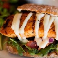 Grilled Salmon Sandwich · Grilled salmon brushed with dill butter and served on a whole wheat bun with arugula, red on...