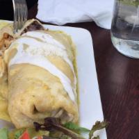 Burrito Bravo · Steak Burrito with Grilled Onions, Jalapenos, and Beans (everything inside) topped with Melt...