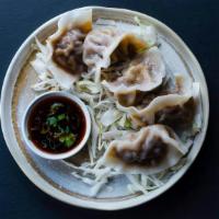 Pork Dumplings (5 Pieces) · Five steamed Pork Dumplings and a side of dumpling dipping sauce.