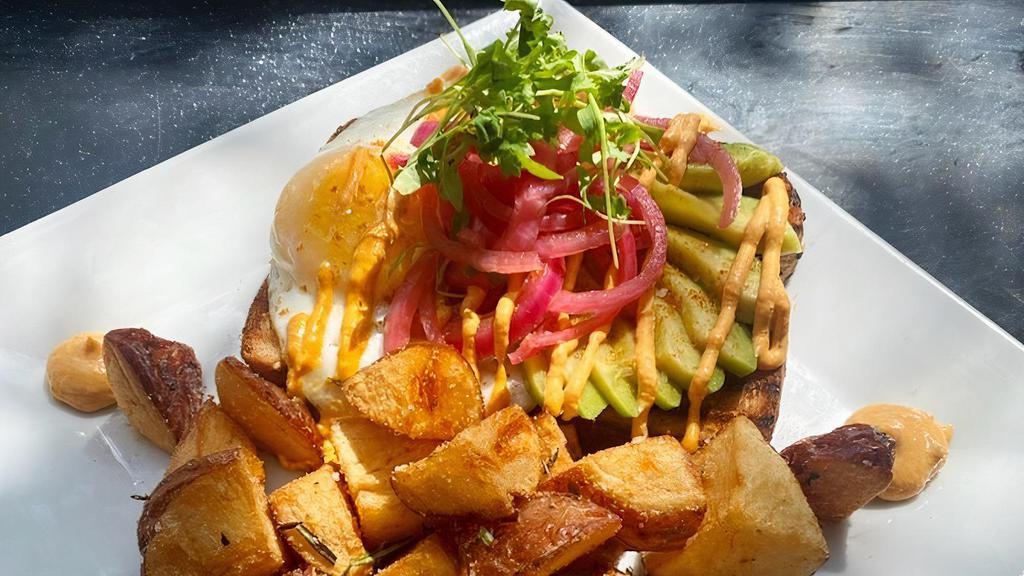 Avocado Toast · Avocado toast with pickled onions, sunny side up egg, cilantro micro greens, carrot chipotle and served with rosemary potatoes