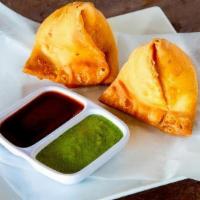 Vegetable Samosa · Pyramid shaped pastry stuffed with potatoes, green peas and spices.