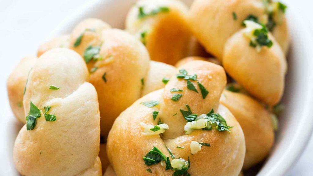 Signature Garlic Knots · Freshly baked with a savory blend of fresh garlic, virgin olive oil, oregano, and parsley finished with parmesan. Served with marinara on the side.