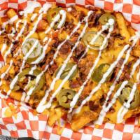 Junkyard Fry · Seasoned Fries covered with warm Nacho Cheese, Chili, Crispy Bacon Pieces, Jalapeño and topp...