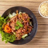 Nam Tok (Grilled Beef Salad) · Char-grilled tender beef slices tossed with toasted rice powder, red onions, scallions and c...