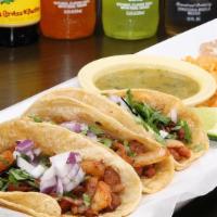 Tacos Al Pastor · Three corn tortillas filled with marinated grilled pork with chunck of pineapple. Onions, ci...