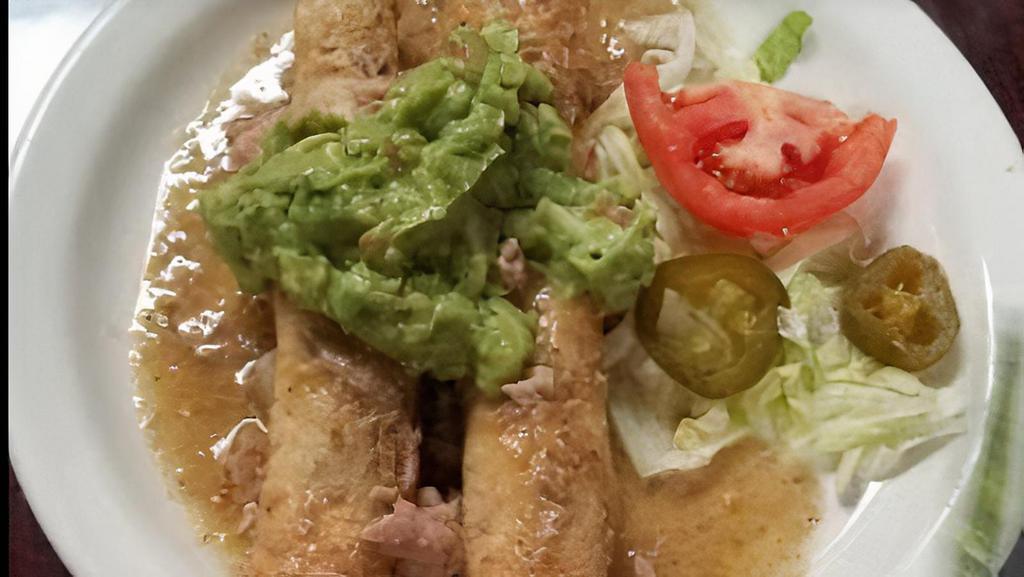 Chicken Flautas · Two crispy flour tortillas stuffed with shredded chicken. Topped cheese sauce. Served with rice, beans, lettuce, guacamole and sour cream.