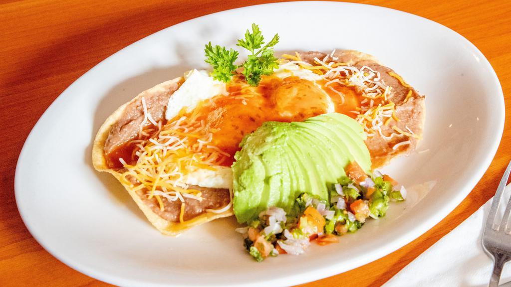 Huevos Rancheros · Two corn tortillas layered with refried beans topped with two eggs cheddar cheese salsa and pico de gallo.