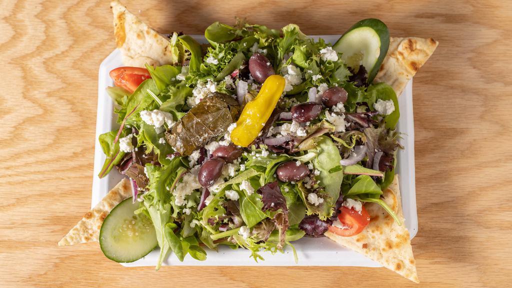 Greek Farmer Salad · Spring mix lettuce, tomatoes, cucumber, red onions, kalamata olives, crumbled feta cheese, pepperoncini & grape leaf with Greek vinaigrette dressing on the side. Served with grilled pita bread