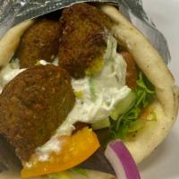 Falafel Sandwich · Served in a warm pita with spring mix lettuce, tomatoes, cucumbers, red  onions &  choice of...