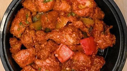 Chili Chicken  · Fried chicken pieces tossed in a spicy chili sauce with onions and bell peppers.