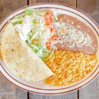Quesadilla Gringa · Pastor,  steak  or  chicken  with  oaxaca  cheese,  rice  and  beans.  served with sour crea...