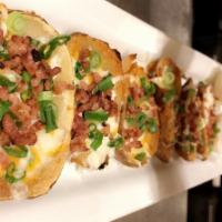 Loaded Potato Skins · Fresh made potato halves, topped with a blend of cheeses and bacon bits. Served with sour cr...