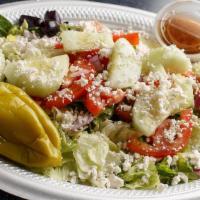 Krilakis Greek Salad · Fresh garden greens, tomatoes, red onions, cucumber, feta cheese, Kalamata olives, and peppe...